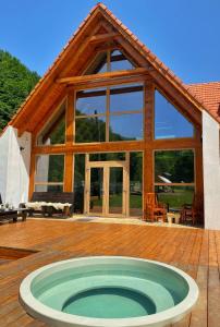 克卢日-纳波卡Scrind 11 - Madleine Chalet的木甲板上带热水浴池的房子