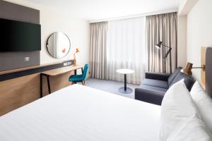 考文垂克文特日M6J2度假旅馆的配有一张床和一把椅子的酒店客房