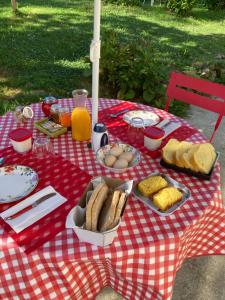 GanacLes chambres d'Agath'ânes的一张野餐桌,上面有食物,放在红色和白色的桌布上