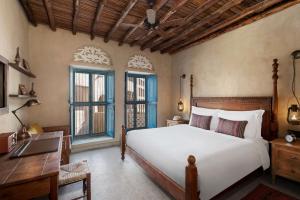 迪拜Al Seef Heritage Hotel Dubai, Curio Collection by Hilton的卧室配有一张床、一张书桌和窗户。
