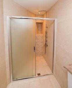 GialtraEast & West Seaside Apartments的浴室里设有玻璃门淋浴
