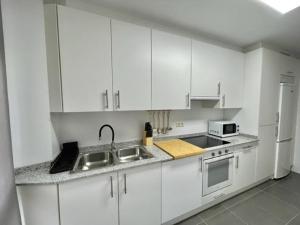 里贝拉Apartamento en palmeira - Colores del Barbanza Naranja的白色的厨房配有水槽和冰箱