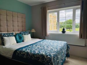 Old WardenThe Garden Suite at Shuttleworth的一间卧室配有一张带蓝色棉被的床和窗户。