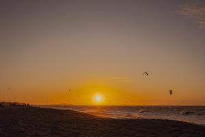 普雷亚Ventana Hotel的一群人在日落时分在海滩上放风筝
