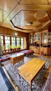 列城Nordan guest house Ladakhi room的一个带木桌和长凳的大客厅