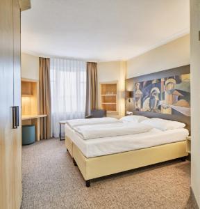 魏玛奥古斯特开森瑞酒店的酒店客房设有一张大床和一张书桌。