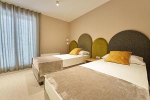 伊佐拉Dolcemente Garni Hotel Superior的酒店客房设有两张床和窗户。