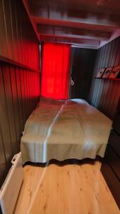 LjørdalFulufjellet的一间小卧室,配有一张带红色窗帘的床