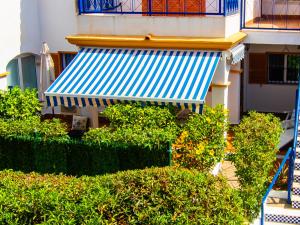 维拉Amigos at Veramar 6的蓝色和白色遮阳篷和灌木丛的建筑
