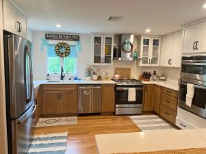 米德尔敦Modern Family Home in Middletown, RI- just 4 mi to Newport!的厨房配有木制橱柜和不锈钢用具