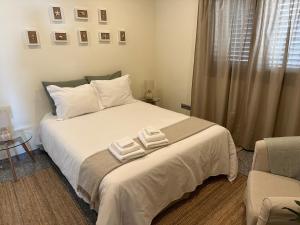 拉布鲁吉Casa de Praia Guest House的一间卧室配有一张床,上面有两条毛巾