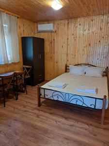 希典Комплекс Джулай Морнинг的一间卧室配有一张带桌子和桌子的床。