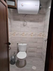 希典Комплекс Джулай Морнинг的浴室配有卫生间和墙上的灯。