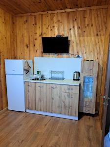 希典Комплекс Джулай Морнинг的厨房配有白色冰箱和木墙