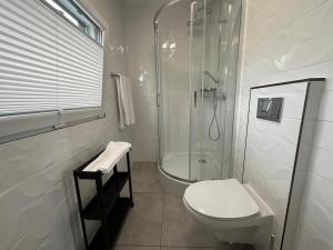 Sun House的带淋浴和卫生间的白色浴室