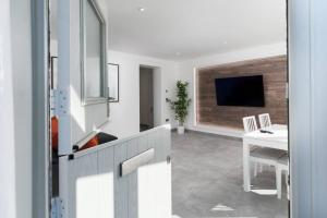 马拉扎恩Stunning new 1 bed apartment in Marazion.的客厅配有电视、桌子和书桌