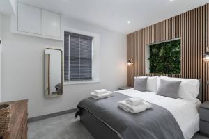马拉扎恩Stunning new 1 bed apartment in Marazion.的一间卧室配有一张床,上面有两条毛巾
