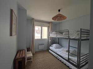 维姆勒Vague d'Opale的一间卧室设有两张双层床和一扇窗户。