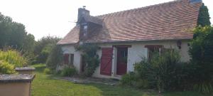Marigné-LailléGîte Les Toisnières的院子中带红色门的小白色房子