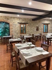 BrancaAgriturismo Akasha的餐厅设有木桌和椅子,拥有砖墙