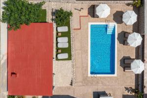 依克希亚Adonis Villa in nature的游泳池和遮阳伞的顶部景色