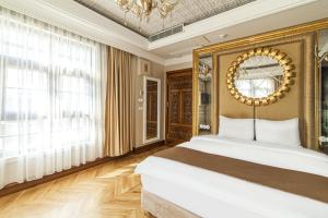 伊斯坦布尔Sakine Hanim Mansion的一间卧室配有一张大床和一个吊灯。