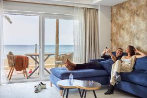 阿尔么丽亚Expoholidays- Apartaments Paseo Marítimo的坐在客厅蓝色沙发上的男女