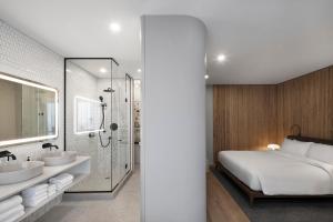 蒙特利尔蒙特利尔日耳曼酒店的一间卧室配有一张床、两个盥洗盆和淋浴。