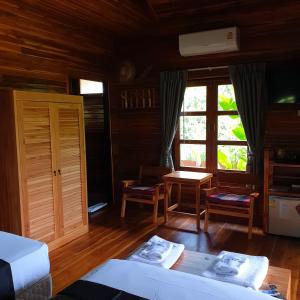 湄南海滩Samui Blue Bird的客房设有两张床、一张桌子和一扇窗户。