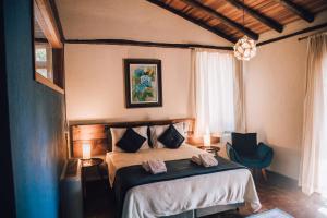 坎波斯杜若尔当Pousada Villa Serena的一间卧室配有一张床,上面有两条毛巾