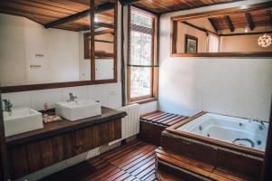 坎波斯杜若尔当Pousada Villa Serena的大型浴室设有两个盥洗盆和浴缸。