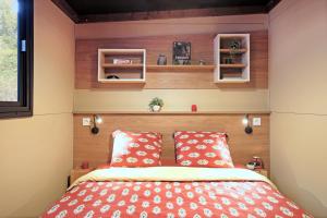 阿卡雄Huttopia Arcachon的小卧室配有红色枕头的床