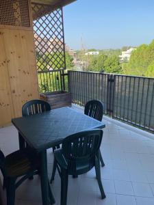 安德里亚Appartamento con veranda Via Castel del Monte的阳台上配有蓝色的桌椅