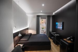 巴里Contemporaneamente 147 - Modern & Comfort Rooms的一间卧室配有一张床、一张书桌和一台电视