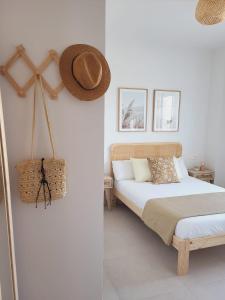 罗塔ÁTICOS ROTA Punta Candor的卧室配有两张床,墙上挂着一顶帽子