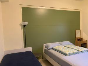 东港Duke369东港民宿的一间卧室配有绿色床头板和一张床