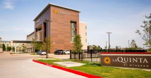 奥斯汀La Quinta Inn & Suites by Wyndham Austin Parmer Tech Ridge的前面有标志的建筑