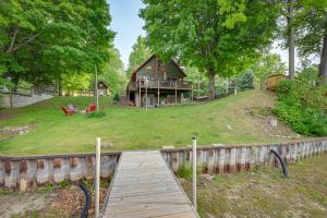 AlgerPeaceful Waterfront Cabin on Tittabawassee River!的一座带木桥的山丘上的房子