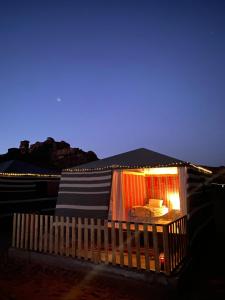 DisahDesert's Soul Wadi Rum的一座小建筑,晚上有床