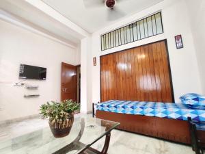 加尔各答Spacious 3BHK House opp South City Mall的客房设有1张床、1张桌子和1台电视。