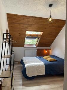 LayeMaison L'Aiguille - 2 appartements, 5 chambres et table d'hôtes au pied de la montagne à la station de Laye的一间卧室设有一张木天花板床。