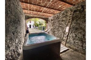 Ozzano MonferratoCascina Liebe con Idromassaggio的一间石墙内带浴缸的浴室