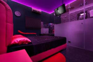 Tel BinyaminMetro Elegance Suites的粉红色的卧室配有床和电视