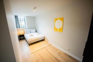 鹿特丹Cool 3 Bedroom Serviced Apartment 68m2的卧室配有一张床,墙上挂着一幅画