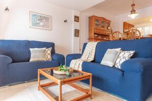 莱斯卡拉Apartamento El Capitan的客厅配有2张蓝色的沙发和1张桌子