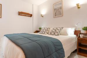 莱斯卡拉Apartamento El Capitan的一间卧室配有一张带蓝色毯子的床