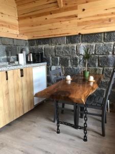 贾马里海姆森Şeni Bungalow的厨房配有木桌和石墙