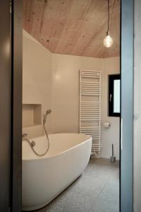 滕普林Elf am See - Haus 7的浴室设有白色浴缸,拥有木制天花板