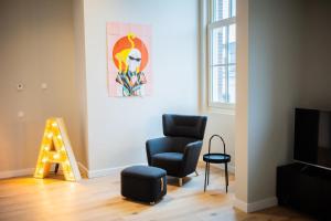 鹿特丹Ample 3 Bedroom Apartment的客厅配有椅子和墙上的绘画