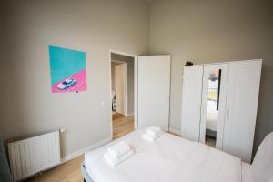 鹿特丹Ample 3 Bedroom Apartment的白色卧室配有床和镜子